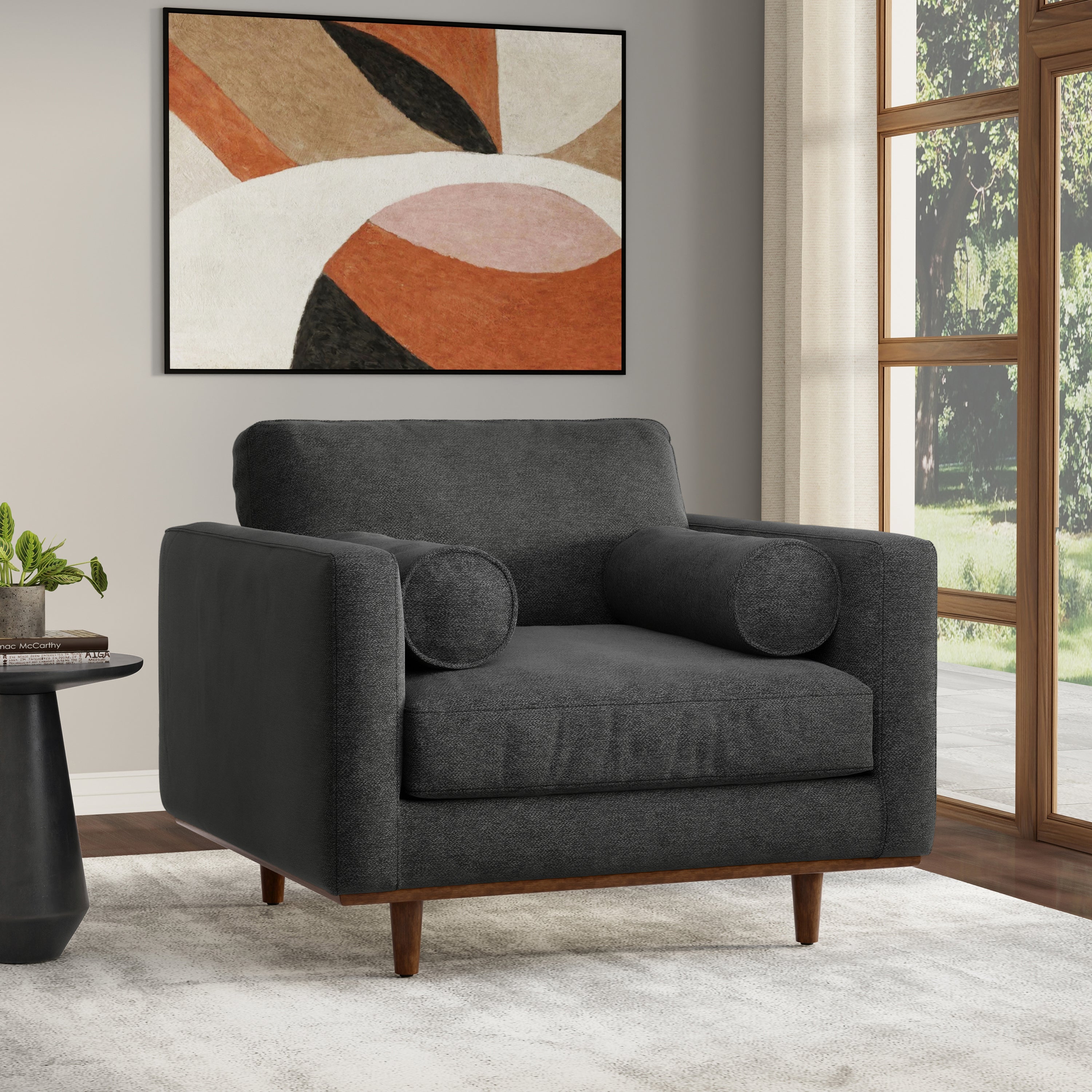 Morrison Arm Chair in Charcoal Grey with mid-century design placed in a modern living room. Features durable wood frame and plush cushions.