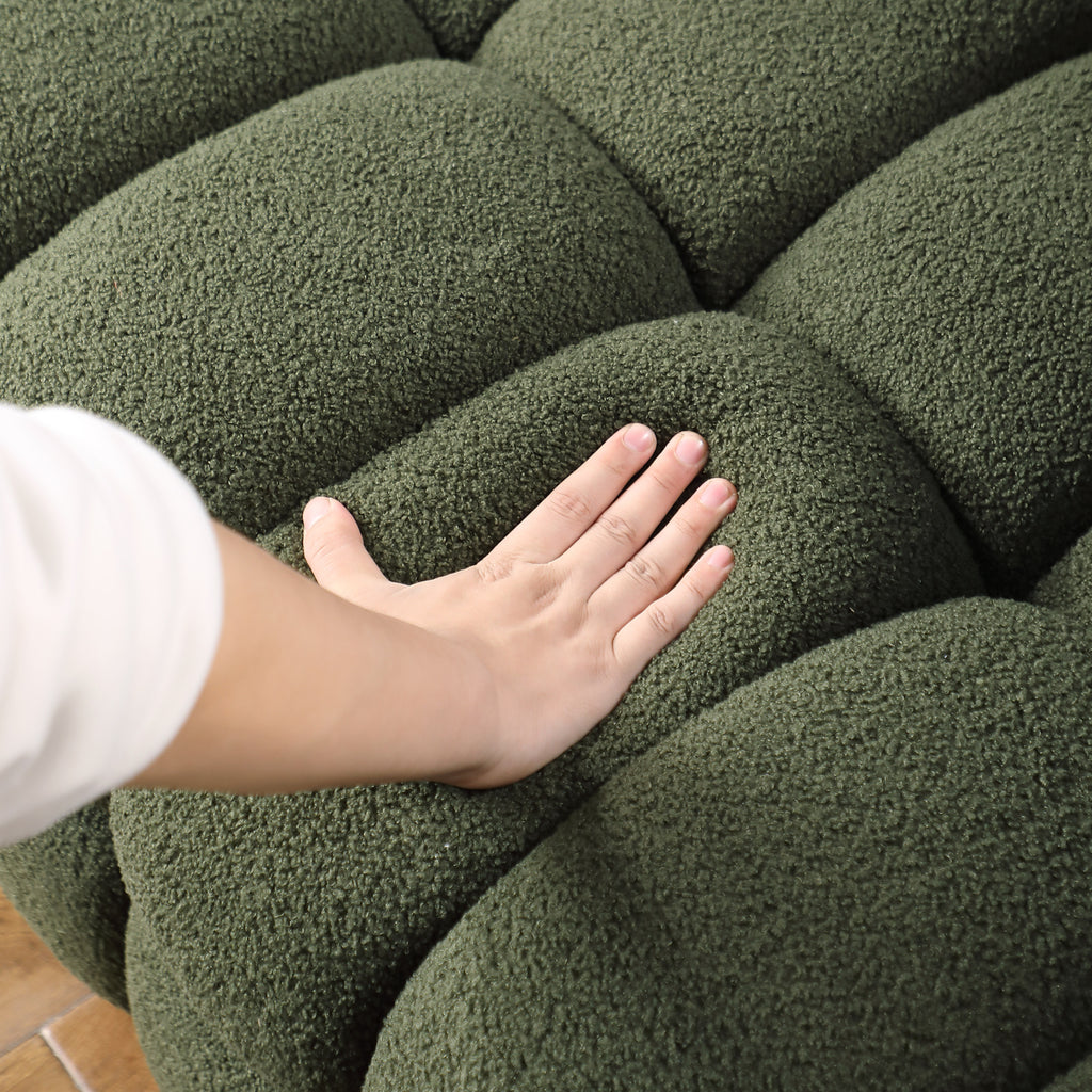 Hand pressing into the cushion of Olive Green Boucle Sofa - 3 Seater, Marshmallow Cozy, highlighting its softness and comfort.