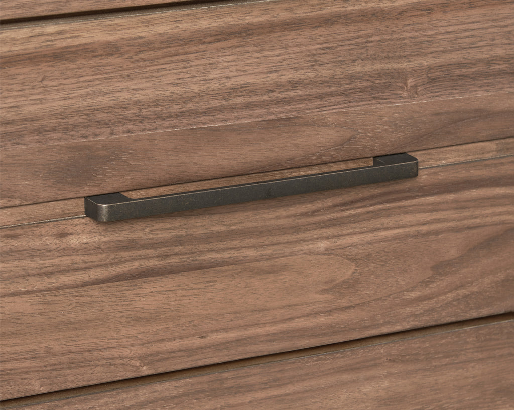 Close-up of antique bronze handle on walnut dresser drawer. Adds a touch of elegance to the modern storage unit.