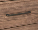 Close-up of antique bronze handle on walnut dresser drawer. Adds a touch of elegance to the modern storage unit.