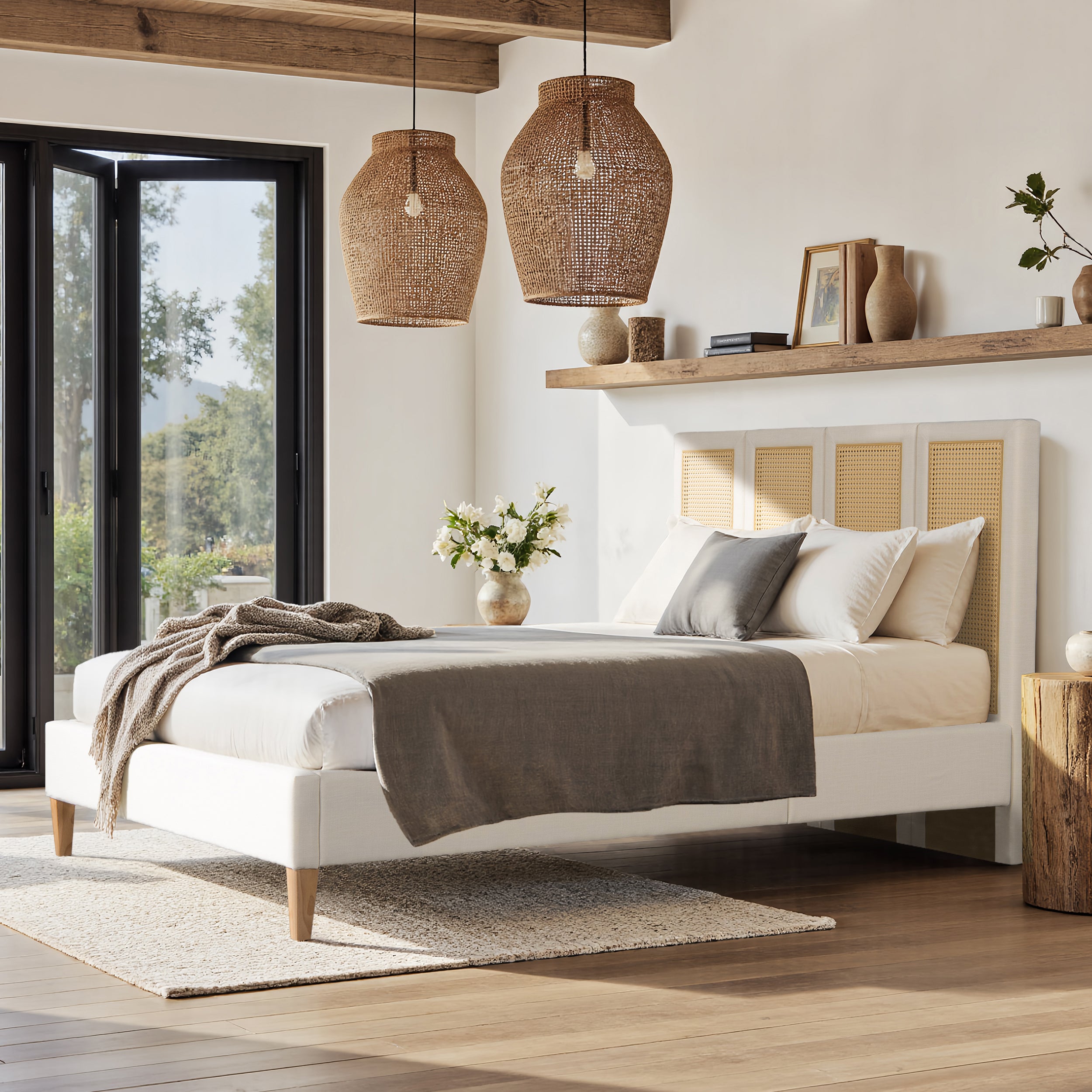 Queen Upholstered Cane Bed in antique white with rattan headboard, placed in a rustic bedroom with wood accents and natural lighting.