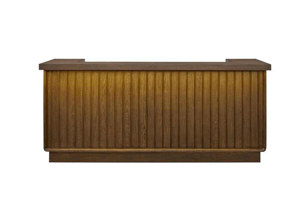Counter-height wooden bar in a latte finish featuring a vertical slat design, flat countertop, and warm, lit front panel.