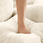Foot sinking into the plush chenille cushion of the Modular L-Shaped Sofa - Sectional Couch, demonstrating its supportive softness.
