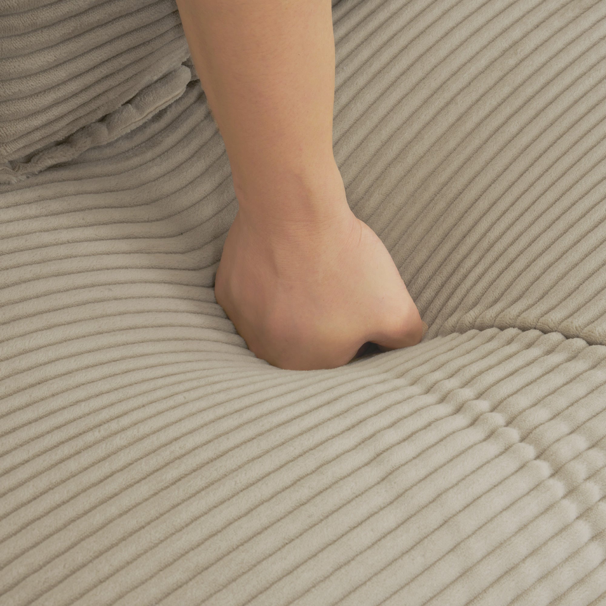 Brown Corduroy Modular Sofa - Adjustable Pillows | Durable hand pressing into soft cushion to demonstrate plushness and comfort level.
