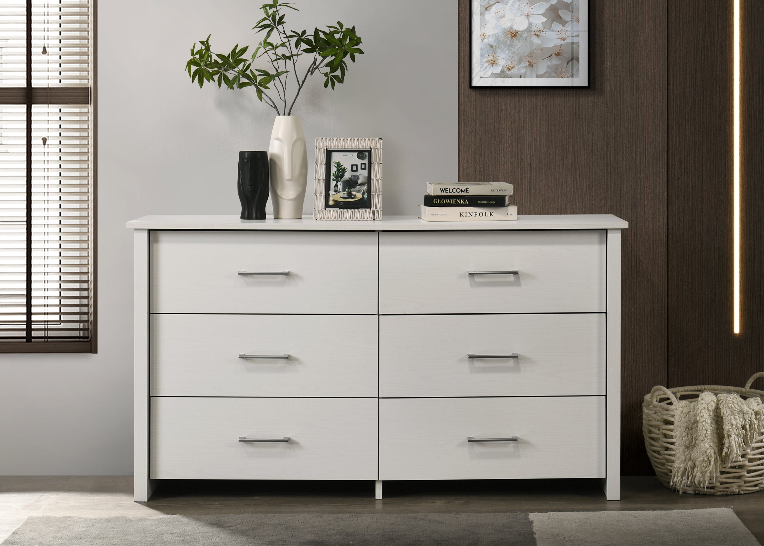 White 6-drawer dresser with silver handles in modern bedroom setting. Features smooth-gliding drawers and stylish decor accents on top.