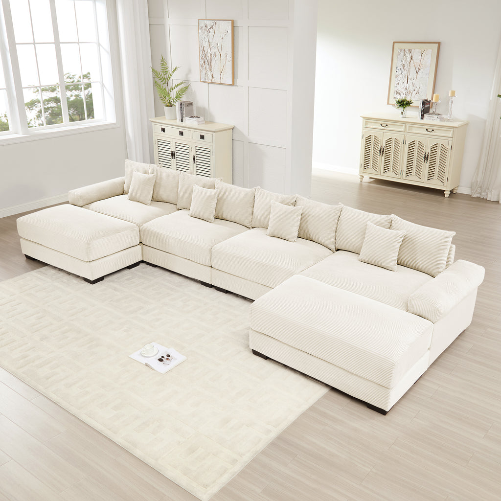 Oversized cream corduroy U-shape modular sectional sofa with deep seats, plush cushions, and a matching ottoman.