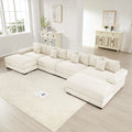 Oversized cream corduroy U-shape modular sectional sofa with deep seats, plush cushions, and a matching ottoman.