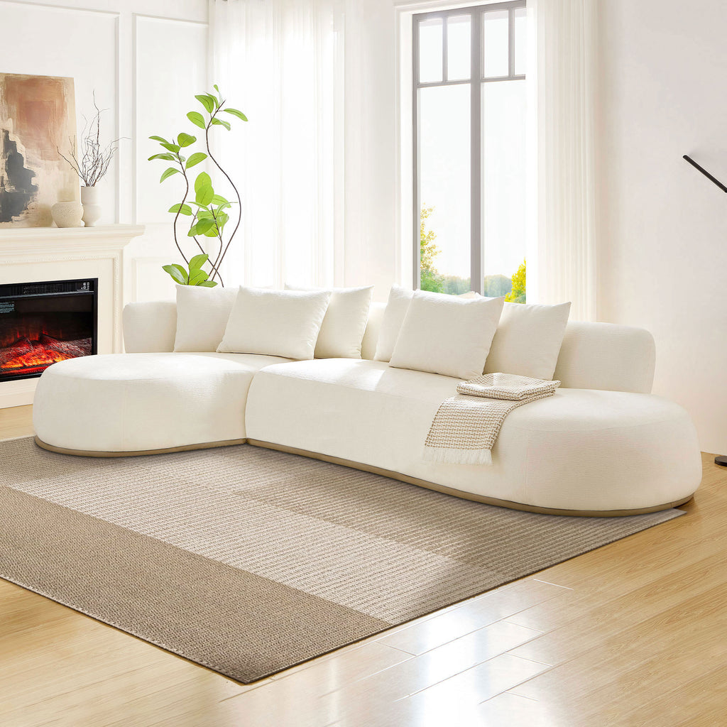 Beige Oversized L-Shape Sectional Sofa with Chaise in a bright living room, featuring soft curves, plush seating, and a neutral area rug.