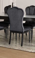 Back view of black dining room side chair with curved upholstered back and fluted legs, styled in a modern dining room.