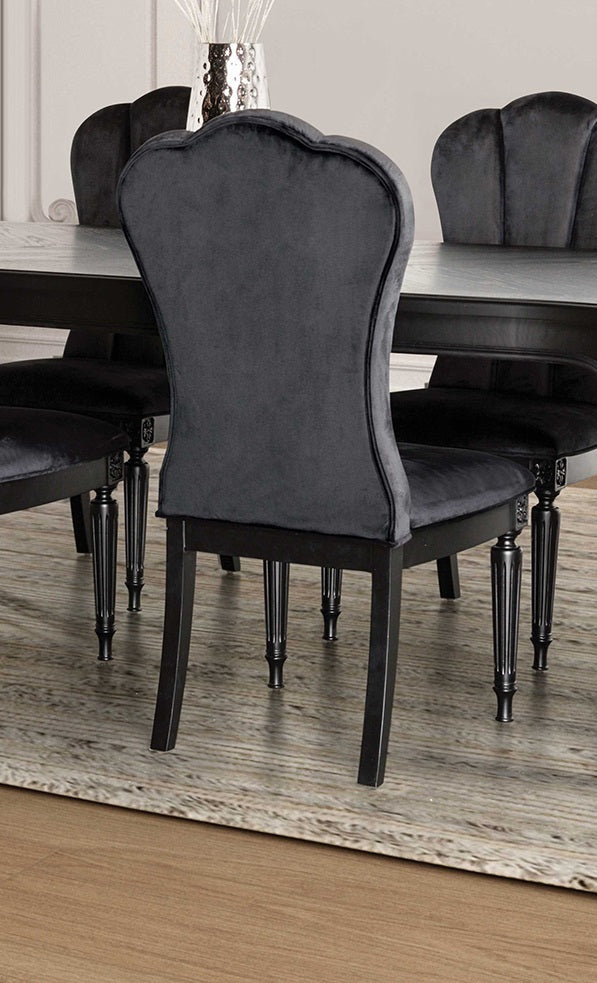 Back view of black dining room side chair with curved upholstered back and fluted legs, styled in a modern dining room.