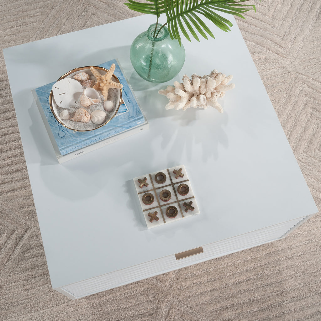 Top view of the white coffee table styled with coastal decor, highlighting its smooth surface and functional design.