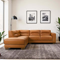 Tan leather L-shaped sectional sofa with plush cushions and low-profile walnut wood legs in a modern living room.
