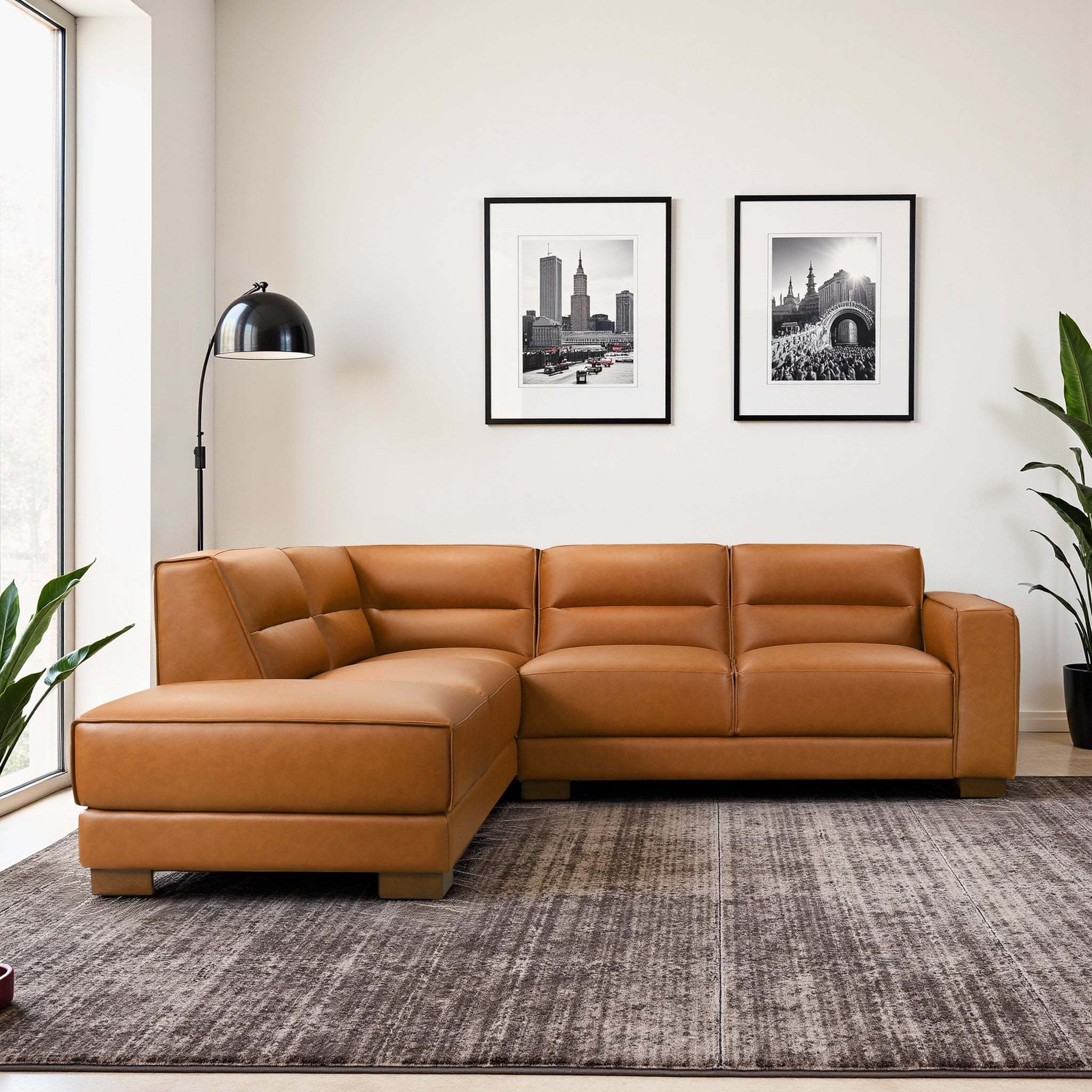 Tan leather L-shaped sectional sofa with plush cushions and low-profile walnut wood legs in a modern living room.