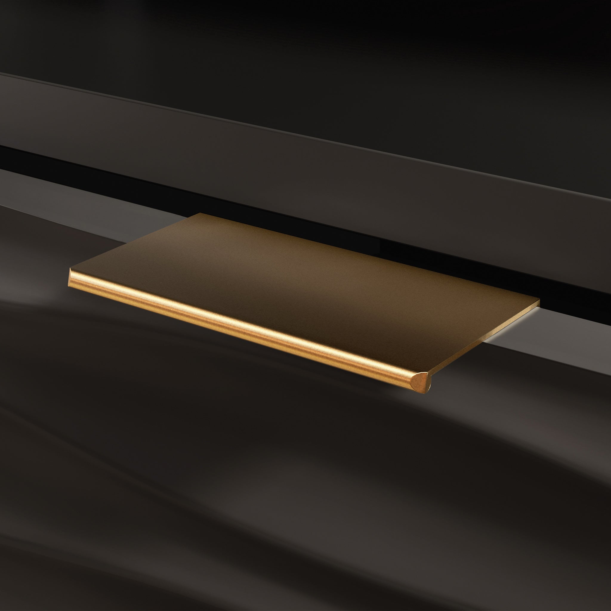 Detail of gold drawer handle on black credenza, highlighting elegant hardware and textured drawer front.