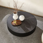 Top view of the modern black round coffee table with sintered stone surface, decorated with minimalist vases and wooden tray.