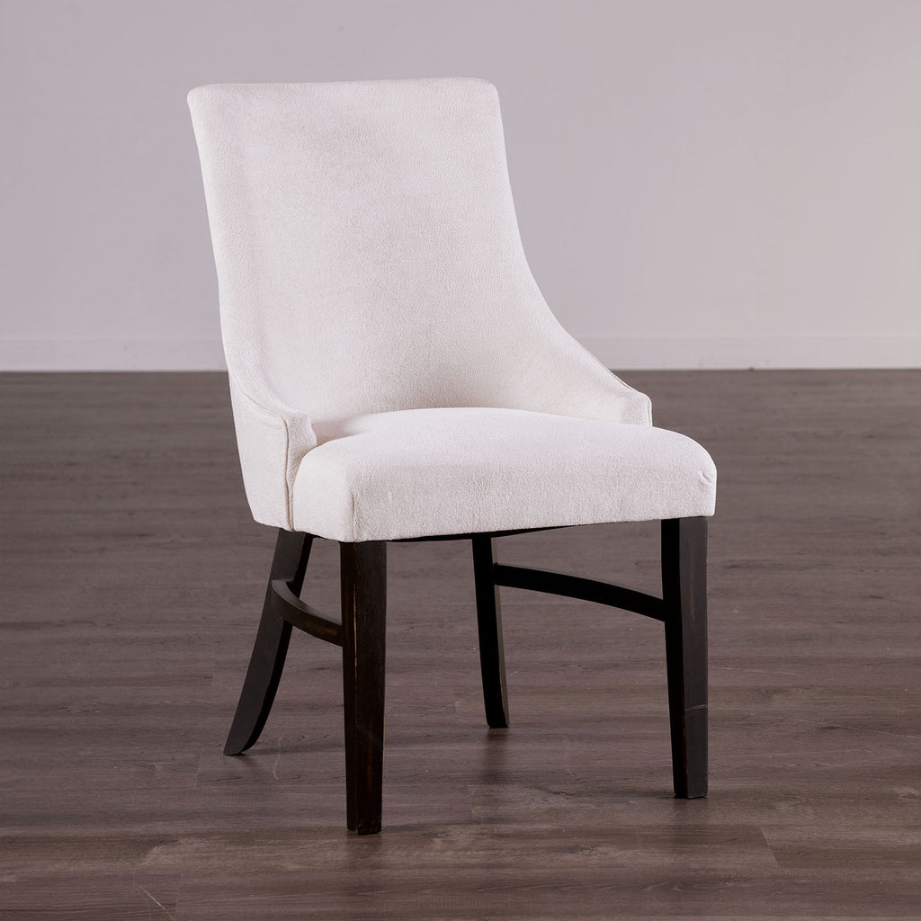 Transitional arm chair with padded wingback in beige fabric and black wood legs, ideal for modern dining room settings.