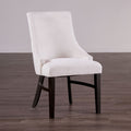 Transitional arm chair with padded wingback in beige fabric and black wood legs, ideal for modern dining room settings.