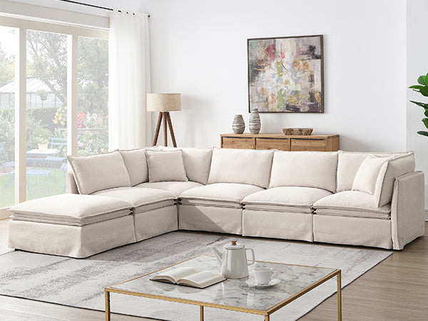 Modular sectional sofa with ottoman in a bright living room, styled with modern decor and natural light for a welcoming atmosphere.