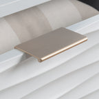 Gold-tone drawer pull on the white coffee table adds a touch of elegance to the coastal-inspired furniture piece.