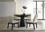 Jasper Dining Set - Black Round Table & Chairs in modern dining room with natural light and neutral decor. Includes 4 cushioned beige chairs.