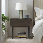Modern dark oak wood nightstand featuring a geometric drawer front and black metal legs, styled in a bedroom setting.