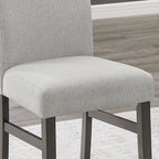 Close-up of Selena Dining Set chair showing soft light gray upholstery and durable dark wood frame for comfort and style.