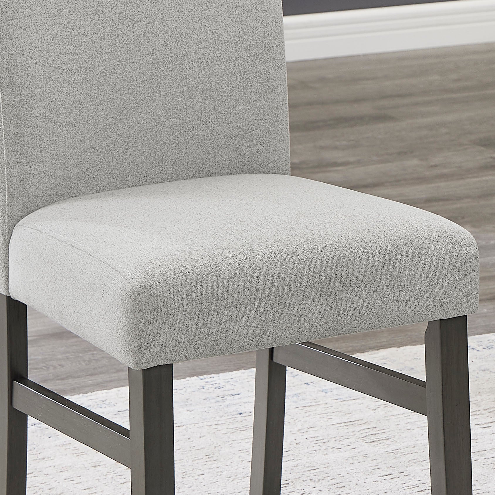 Close-up of Selena Dining Set chair showing soft light gray upholstery and durable dark wood frame for comfort and style.