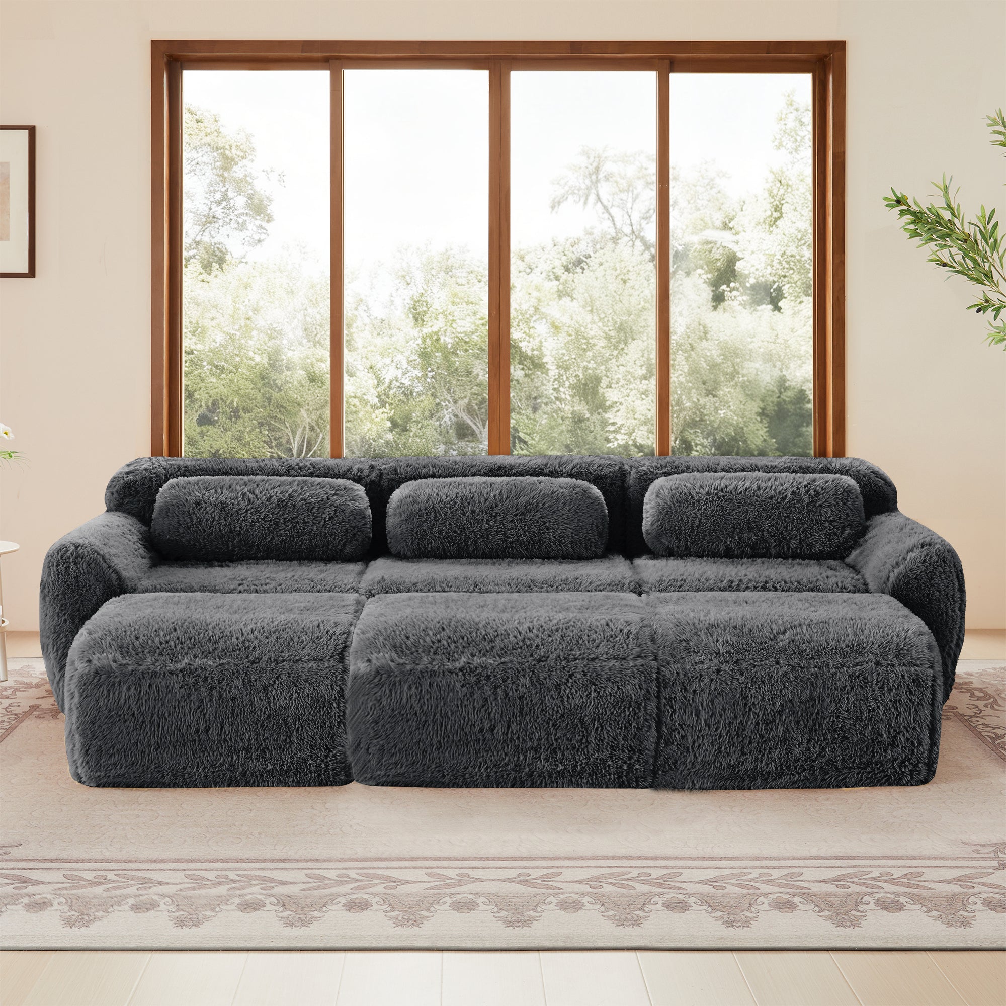 Dark grey 3-seater modular plush sofa with deep cushions and movable ottoman, ideal for modern living spaces.