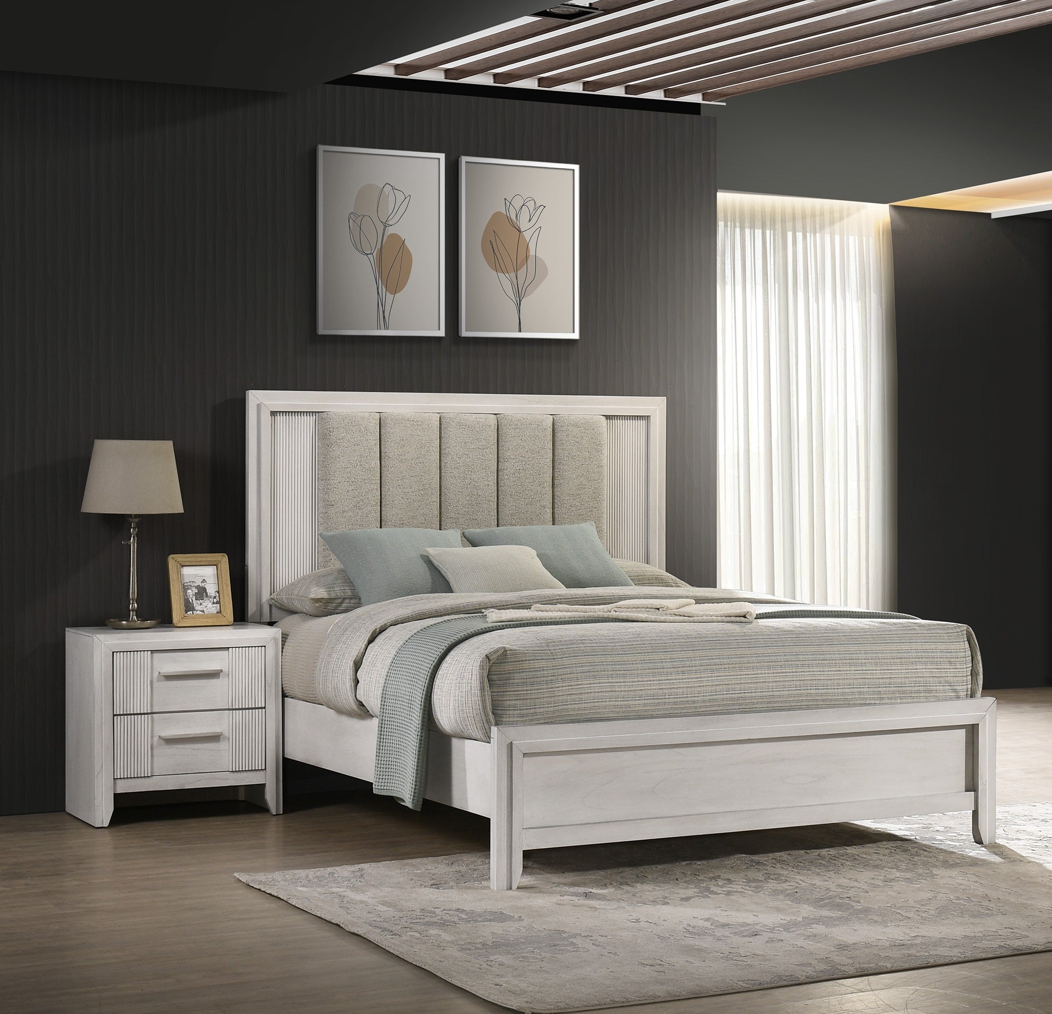 Queen size bed in white finish with upholstered headboard, paired with matching nightstand in a modern bedroom setup.