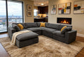 Modern dark gray modular sectional sofa with yellow toss pillows, featuring textured fabric and a draped cream throw.