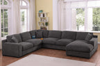 Gray chenille sectional sofa with right-facing chaise, charging ports, and cupholders in a bright living room with wood flooring.