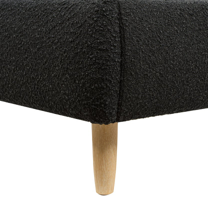 Close-up of Curved Upholstered Platform Bed Queen, Ebony Black Boucle showing textured fabric and tapered wooden leg detail.