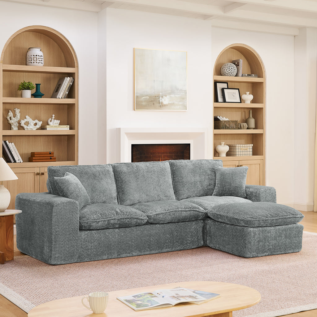 Modern gray boucle sectional sofa with a reversible chaise, plush cushions, and matching throw pillows in a cozy room.