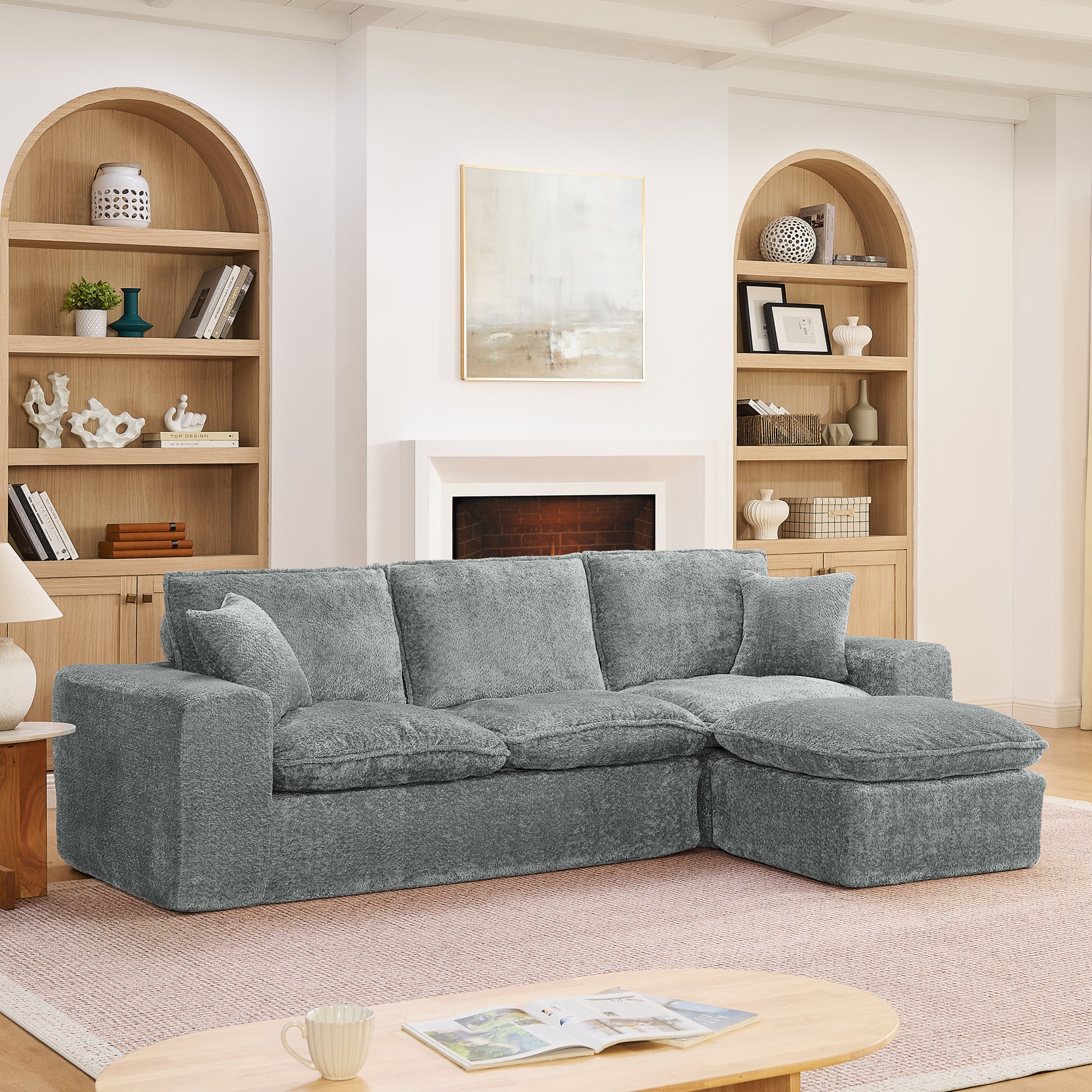 Modern gray boucle sectional sofa with a reversible chaise, plush cushions, and matching throw pillows in a cozy room.