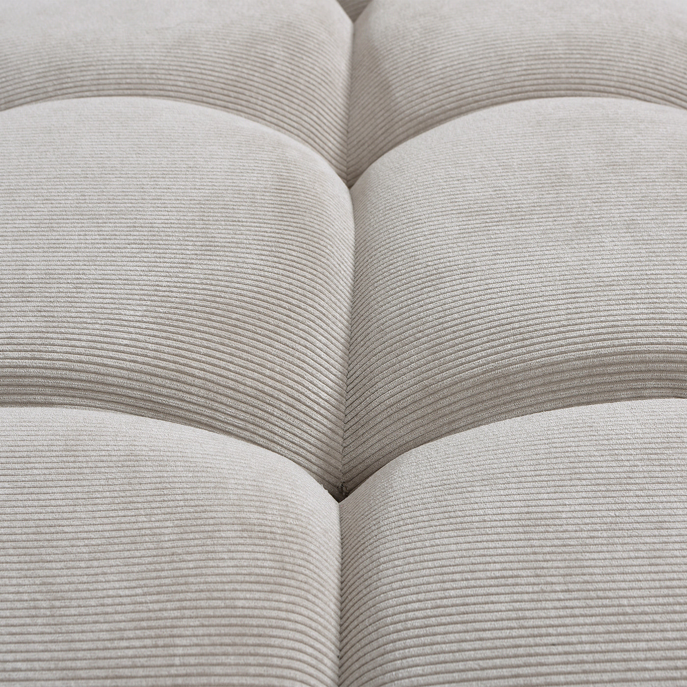 Detailed view of the tufted corduroy seat on the modern gray lounge arm chair, highlighting soft foam filling and ribbed texture.