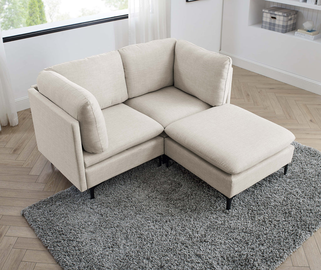 Beige linen modular sectional sofa with plush cushions and black metal legs, set on a gray rug.