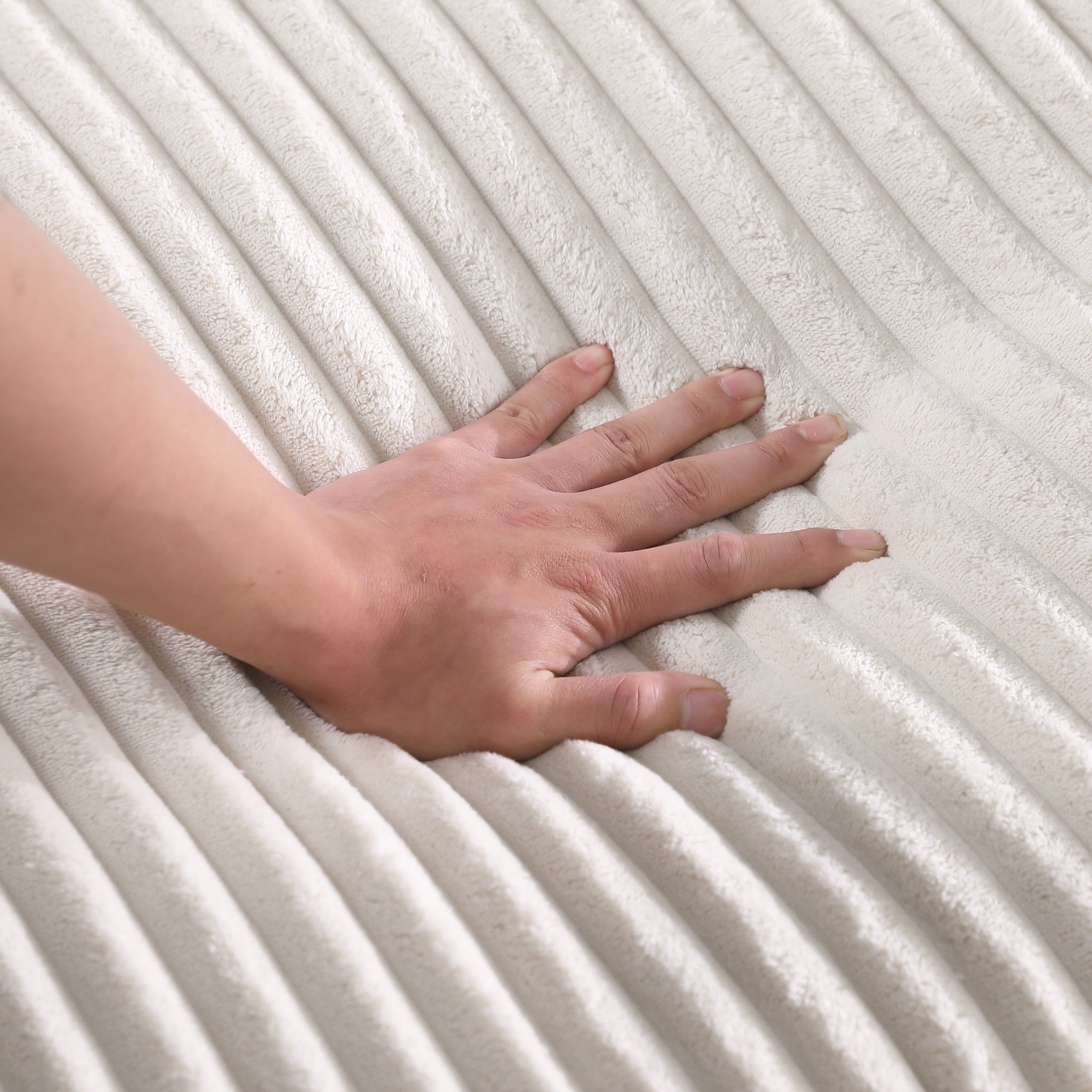Hand pressing into plush corduroy fabric of Beige Corner Sofa, demonstrating its soft and supportive cushioning.