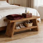 Rustic wooden 2-tier shoe bench at the foot of a bed, featuring a top surface with a velvet pillow and storage shelf.