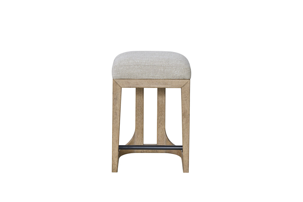 Modern rustic counter-height stool featuring a beige upholstered seat, light wood frame, and a black metal footrest.