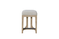 Modern rustic counter-height stool featuring a beige upholstered seat, light wood frame, and a black metal footrest.