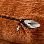 Close-up of zippered cushion cover on modern L-shape sectional sofa, revealing removable and washable design for easy maintenance.