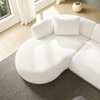 Curved chaise detail of L-Shape Sectional Sofa Beige, placed near window with natural light and cozy rug.