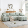 Modular sectional sofa with ottoman in boucle fabric, styled in a modern living room with wood accents and neutral tones.