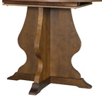 Close-up of pedestal base of farmhouse dining table with curved wood detailing. Adds elegance to rustic dining furniture.