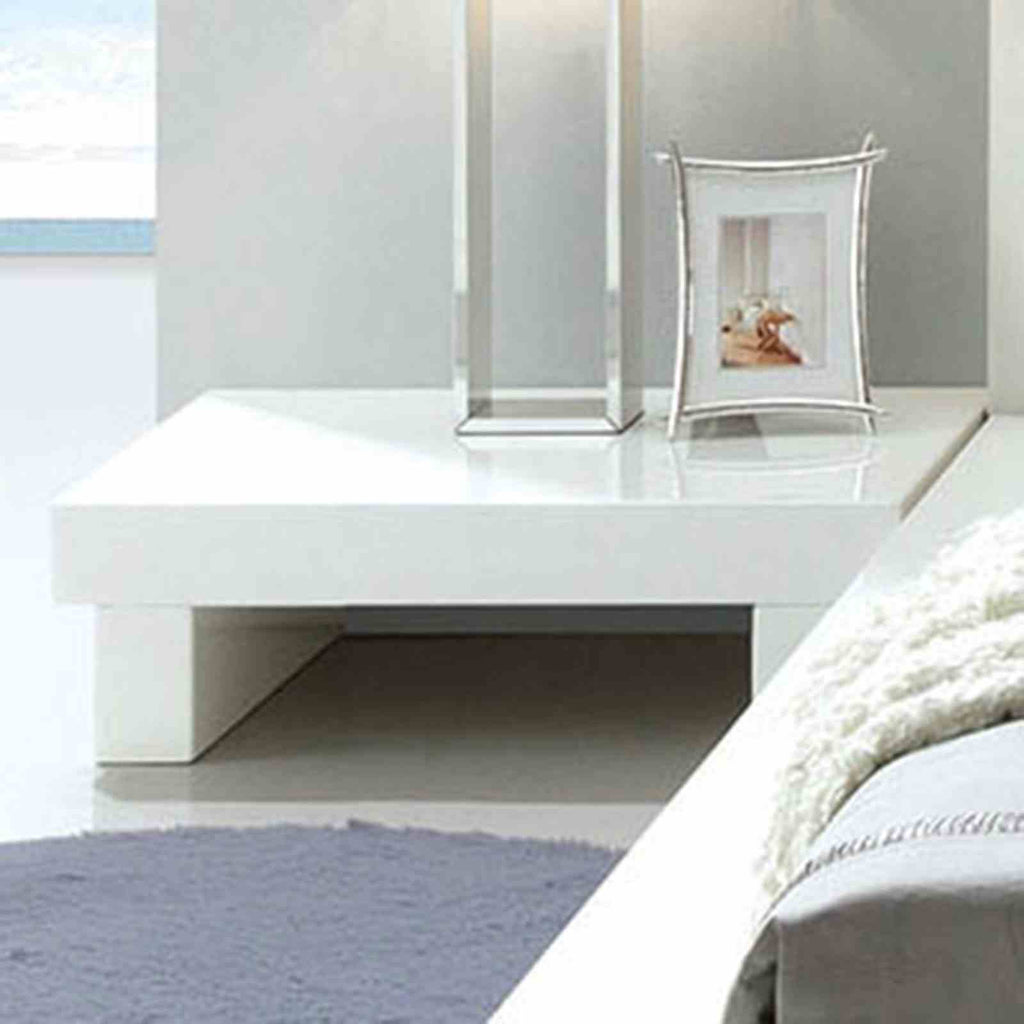 Contemporary low-profile nightstand in high-gloss white lacquer with a minimalist block design.