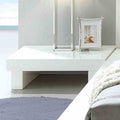 Contemporary low-profile nightstand in high-gloss white lacquer with a minimalist block design.