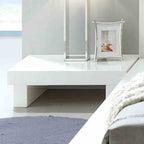 Contemporary low-profile nightstand in high-gloss white lacquer with a minimalist block design.