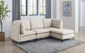 Beige linen modular sectional sofa with plush cushions and sleek black metal legs on a grey area rug in a bright room.