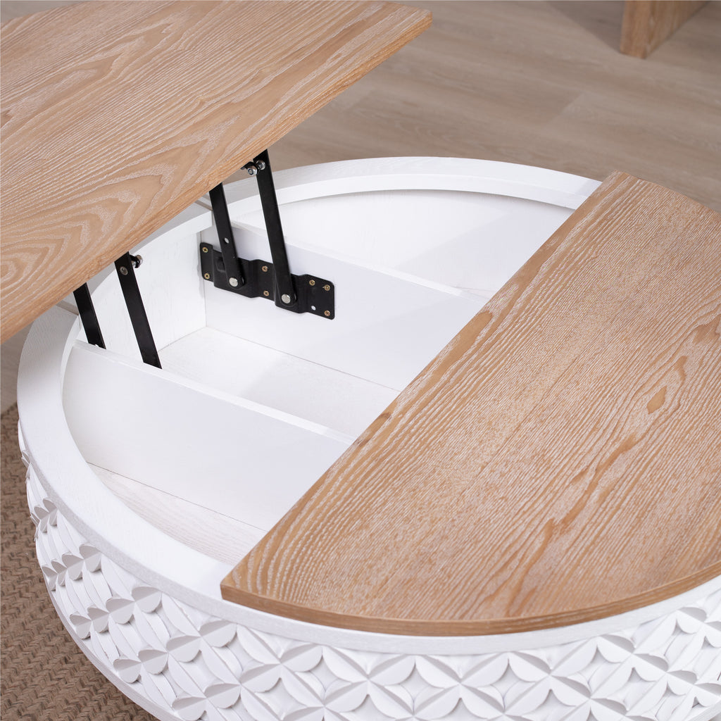 Close-up of lift-top storage compartment in round coffee table with white carved base and wood top.