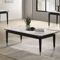 Contemporary coffee table with sintered stone top in black and white, featuring silver-capped tapered legs, styled in a modern living room.